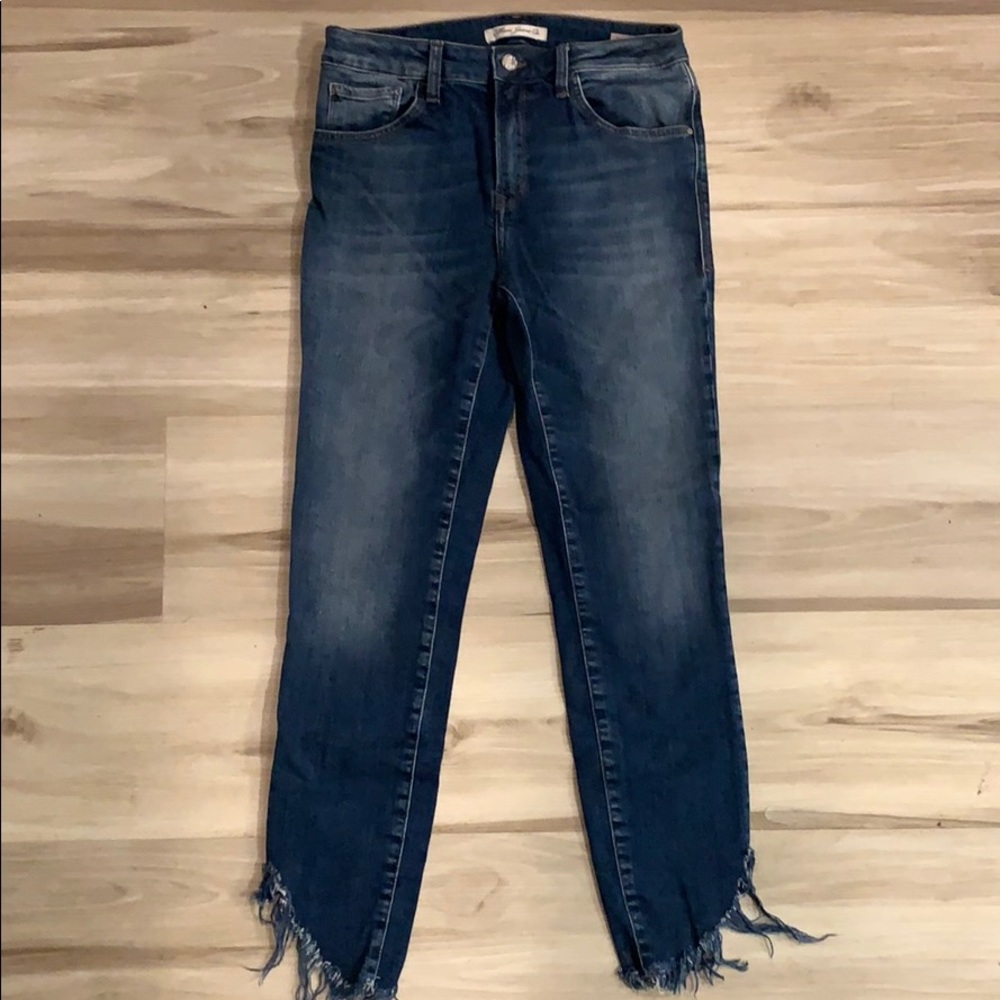 Dark wash jeans with fringe detail on bottoms